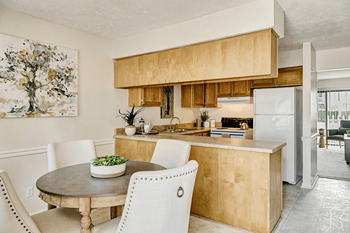 A kitchen with a table and chairs in front of it.at Patriot Point Apartment Homes, Spring Lake 